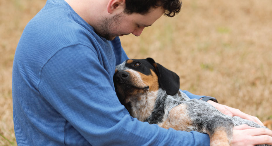 Owner cuddling dog 
